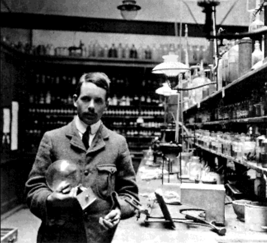 Henry Mosley in his lab holding a glass sphere.
